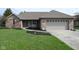 Charming brick home featuring an attached garage and a well-maintained lawn with black mulch at 16 Corkwood Ct, Brownsburg, IN 46112