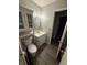 Bathroom with toilet with handicap assistance, sink, mirror, and storage at 2126 Dawnshire Dr, Columbus, IN 47203