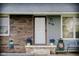 Inviting front door with brick accents, potted flowers, a small bench, and visible house number at 2126 Dawnshire Dr, Columbus, IN 47203