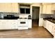 Bright kitchen with white cabinets, black countertops, stainless steel appliances, and new flooring at 2126 Dawnshire Dr, Columbus, IN 47203