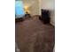 Comfortable living area featuring neutral carpet, a dark television stand, and abundant natural light at 2126 Dawnshire Dr, Columbus, IN 47203
