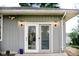 Exterior view of sliding glass doors with outdoor lighting and gray siding at 2126 Dawnshire Dr, Columbus, IN 47203