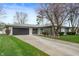 Charming ranch-style home with a stone facade, well-maintained lawn, and gray garage doors at 2200 W Christy Ln, Muncie, IN 47304