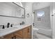 Modern bathroom with double sink vanity, decorative tile accent wall, and shower/tub combo at 2209 Carrollton Ave, Indianapolis, IN 46205