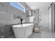 Bathroom featuring a standalone tub, tiled walls, and natural light at 2209 Carrollton Ave, Indianapolis, IN 46205