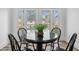 Dining area features a modern round table with luxury vinyl plank flooring and bright lighting at 2209 Carrollton Ave, Indianapolis, IN 46205