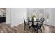 Dining area features a modern round table with luxury vinyl plank flooring and bright lighting at 2209 Carrollton Ave, Indianapolis, IN 46205