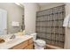 Neutral bathroom with a vanity, decorative shower curtain, and a framed mirror at 225 N New Jersey St # Apt 48, Indianapolis, IN 46204