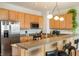 Well-lit kitchen with stainless steel refrigerator, light wood cabinets, and a breakfast bar with seating at 225 N New Jersey St # Apt 48, Indianapolis, IN 46204