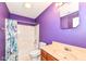 Bright bathroom with a shower-tub combination, and a sink vanity with purple painted walls at 229 Waterford Ct, Avon, IN 46123