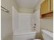 Bathroom featuring a shower-tub combo with white tiling and wooden cabinets at 2606 Bristlecone Dr, Indianapolis, IN 46217