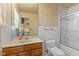 Tiled bathroom features a wood vanity, toilet, and shower with glass door at 2753 N High School Rd, Indianapolis, IN 46224