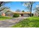 Cozy single-story brick home with a well-maintained lawn, mature trees, and an attached one car garage at 2753 N High School Rd, Indianapolis, IN 46224