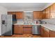 Traditional kitchen with wood cabinets, stainless steel refrigerator, and double basin sink at 2753 N High School Rd, Indianapolis, IN 46224