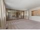 Open living room with mirrored fireplace wall, neutral carpet, and bright natural light at 2753 N High School Rd, Indianapolis, IN 46224