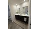 Contemporary bathroom featuring dual sinks, a dark vanity, stylish mirror, and modern fixtures at 280 Walker Dr, Whiteland, IN 46184