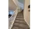 Carpeted staircase with white railing, connecting different levels of a home with views of the living area at 280 Walker Dr, Whiteland, IN 46184