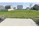 A large, grassy backyard stretches out from a concrete patio, with a neighborhood of homes in the distance at 321 Bluestem Ln, Whiteland, IN 46184
