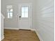 Bright entryway featuring a decorative front door, shiplap accent wall, and wood-look flooring at 321 Bluestem Ln, Whiteland, IN 46184