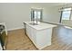 Spacious kitchen island with sink, white countertops, and view to bright and open living area at 321 Bluestem Ln, Whiteland, IN 46184