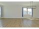 Bright, open living room with wood floors, lots of natural light, and modern light fixture at 321 Bluestem Ln, Whiteland, IN 46184