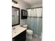 Neutral bathroom with a dark vanity, decorative cabinet, light blue shower curtain and modern lighting at 3333 Lupine Dr, Indianapolis, IN 46224