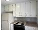 Galley kitchen features bright white cabinetry, light countertops and all appliances at 3333 Lupine Dr, Indianapolis, IN 46224
