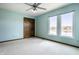 Bedroom boasts calming turquoise walls, two windows overlooking a lake, ceiling fan and wood door at 3634 W 58Th St, Indianapolis, IN 46228