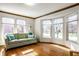 Bright living room featuring hardwood floors, large windows, and a comfortable green couch with pillows at 3634 W 58Th St, Indianapolis, IN 46228