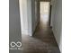 View of a long hallway with dark wood-look floors and white walls leading to several rooms at 3915 Donaldson Creek Ct, Clayton, IN 46118