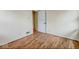 A simple bedroom showcases wood-look floors and an open door leading to another room at 3924 E 30Th St, Indianapolis, IN 46218