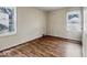 Neutral bedroom with laminate floors and two windows bringing in natural light at 3924 E 30Th St, Indianapolis, IN 46218