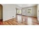 Bright living room features wood-look floors, a front door and windows, and a doorway to another room at 3924 E 30Th St, Indianapolis, IN 46218