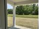 View of the backyard with lush green space and tree line, as seen from a covered porch at 3933 Donaldson Creek Ct, Clayton, IN 46118