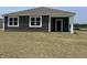 Rear exterior view featuring a modern dark siding, white trim, and manicured backyard at 3933 Donaldson Creek Ct, Clayton, IN 46118