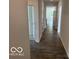 The bright hallway offers durable laminate flooring, white walls and doors, and natural light coming through the home at 3933 Donaldson Creek Ct, Clayton, IN 46118