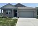 Charming single-story home featuring a grey brick facade, a well-manicured lawn, and a paved driveway at 3949 Donaldson Creek Ct, Clayton, IN 46118