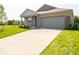 Well-manicured lawn leads to a charming home with a gray garage door and matching trim at 3949 Donaldson Creek Ct, Clayton, IN 46118