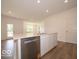 Open kitchen showcases an island with white cabinets, stainless steel appliances and luxury vinyl flooring at 3949 Donaldson Creek Ct, Clayton, IN 46118