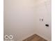 A laundry room showcasing white walls, wood-look floors, and a wire shelf for storage at 3949 Donaldson Creek Ct, Clayton, IN 46118