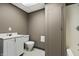 Modest bathroom featuring a single sink vanity, toilet, and shower-tub combo with neutral-toned walls at 3970 Broadway St, Indianapolis, IN 46205