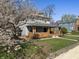 Two-story house with a brick-accented porch surrounded by a manicured lawn and flowering trees at 3970 Broadway St, Indianapolis, IN 46205