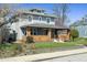 Gray two-story home with a welcoming front porch, landscaped yard, and flowering trees adding curb appeal at 3970 Broadway St, Indianapolis, IN 46205