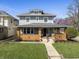 Charming two-story home with a brick-accented porch, green lawn, and flowering tree at 3970 Broadway St, Indianapolis, IN 46205