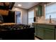 Updated kitchen features stainless steel appliances, green cabinets with gold hardware, and butcher block counters at 4547 Farrington Ave, Indianapolis, IN 46201