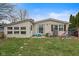 Charming backyard with lush lawn, small patio, and mature trees creating a private outdoor space at 49 Fountain Lake Dr, Greenfield, IN 46140