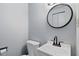 Clean bathroom features a modern round mirror above a stylish white sink and vanity at 49 Fountain Lake Dr, Greenfield, IN 46140