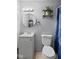 Bathroom features a white vanity, a toilet, a modern circular mirror and blue shower curtain at 49 Fountain Lake Dr, Greenfield, IN 46140