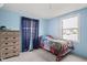 A vibrant bedroom is adorned with blue walls and a dinosaur-themed bedspread at 49 Fountain Lake Dr, Greenfield, IN 46140