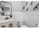 Bathroom featuring a modern square mirror over a white vanity and artistic bird wall decor at 5252 N College Ave, Indianapolis, IN 46220